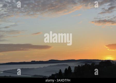 Paesaggio collinare in un mare di nebbia con romantici tramonti e formazioni di nuvole Foto Stock