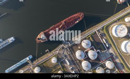 Vista dall'alto del terminal di carico e scarico delle navi petrolifere. Silos di stoccaggio per gas e liquidi. Autocisterna in porto. Spedizione logistica globale. Foto Stock