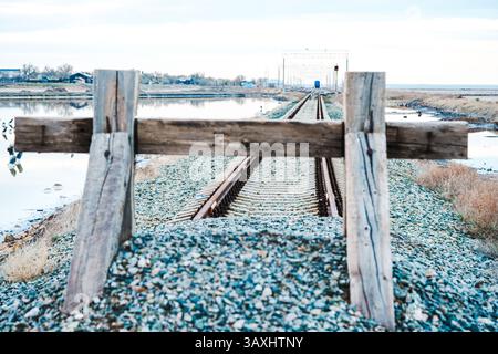 Fine della strada. I binari ferroviari sono ricoperti di ghiaia e ricoperti da una recinzione di legno. Vicolo cieco, zona chiusa. Il concetto di non via d'uscita, alienato Foto Stock