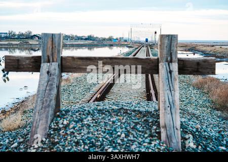 Fine della strada. I binari ferroviari sono ricoperti di ghiaia e ricoperti da una recinzione di legno. Vicolo cieco, zona chiusa. Il concetto di non via d'uscita, alienato Foto Stock