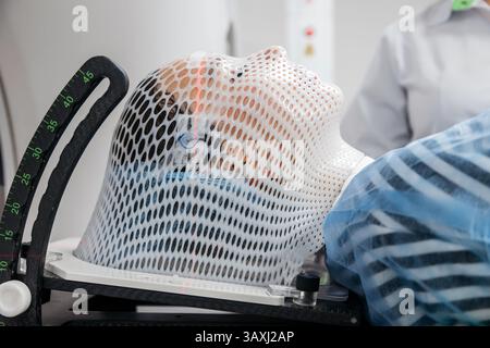 Primo piano delle marcature applicate alla maschera di immobilizzazione per una diagnosi accurata della posizione del tumore. Concetto di moderna tecnologia medica avanzata. Foto Stock