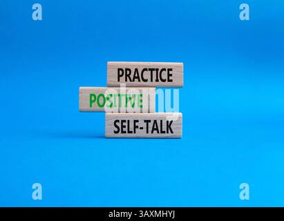 Esercitarsi con il simbolo di autoapprendimento positivo. Le parole concettuali esercitano un'autocomunicazione positiva su blocchi di legno. Bellissimo sfondo blu. Deposito per affari e pratica Foto Stock