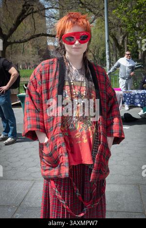 Ritratto in posa di una donna vestita di rosso con capelli rossi e tendine rosse. Al 420 fumare marijuana nel Washington Square Park nel Greenwich Village. Foto Stock