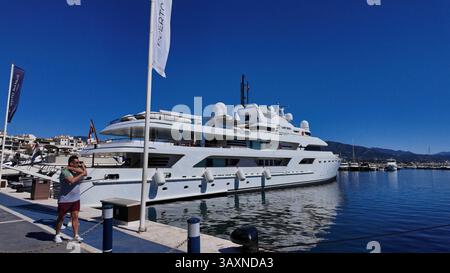 Grande yacht privato bianco che riflette sull'acqua blu perfettamente immobile nel porto turistico di Puerto Banus, MARBELLA, SPAGNA - MARBELLA, SPAGNA - 30 MARZO 2025 Foto Stock