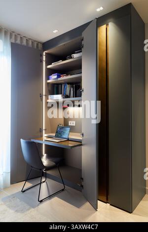Un'idea funzionale con una piccola scrivania per lavorare in un guardaroba nero nella camera da letto di un giovane, design degli interni, Home, Paesi Baschi, Spagna Foto Stock