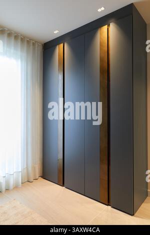 Un'idea funzionale con una piccola scrivania per lavorare in un guardaroba nero nella camera da letto di un giovane, design degli interni, Home, Paesi Baschi, Spagna Foto Stock