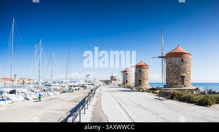 L'iconico trio di mulini a vento visto il 7 aprile 2025 lungo la passeggiata del porto di Rodi in Grecia. Foto Stock