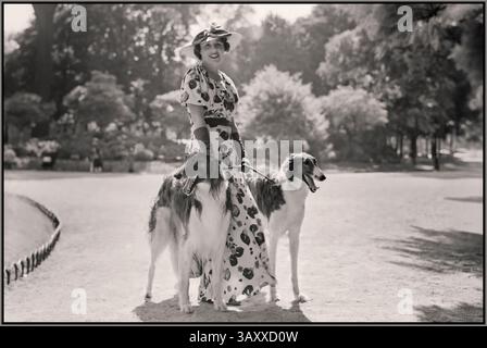 Parigi anni '1930 stile di vita francese donna donna modella Bois de Boulogne Moda fotografia Descrizione : donna con due cani due cani Borzoi, noto anche come Wolfhounds russo nel Bois de Boulogne Data : giugno 1936 Foto Stock