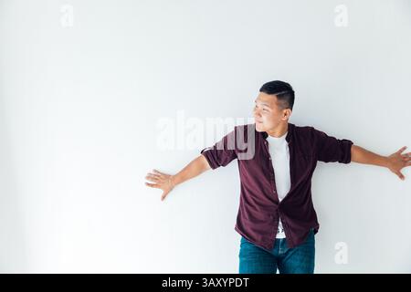 Uomo asiatico che balla con la musica da solo in camera Foto Stock