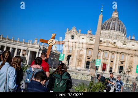 Vatikanstadt, Vaticano. 22 aprile 2025. Un gruppo di pellegrini tedeschi che portano con sé una croce di legno e pregano sulla strada per la Basilica di San Pietro. Stanno piangendo Papa Francesco. Il capo di oltre 1,4 miliardi di cattolici è morto di ictus il lunedì di Pasqua nella sua residenza in Vaticano all'età di 88 anni. Crediti: Christoph Reichwein/dpa/Alamy Live News Foto Stock