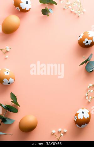 Buona Pasqua, design per banner verticali. Uova di Pasqua e fiori su sfondo rosa pastello. Stile minimalista. Foto Stock