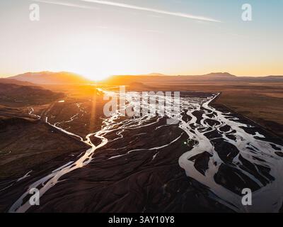 Tramonto sul fiume glaciale intrecciato che scorre attraverso una vasta pianura vulcanica in Islanda. Foto Stock