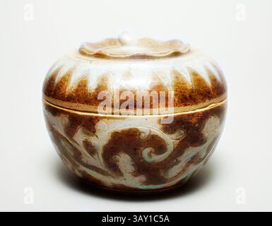 Una pentola in ceramica splendidamente realizzata con fantasie floreali e tonalità terrose, evidenziata da un delicato coperchio che aggiunge un tocco elegante., Thai, Covered Box, 1378/1767, gres smaltato, 4 5/8 x 3/4 cm, arte classica con un tocco moderno reinventata da Artotop Foto Stock