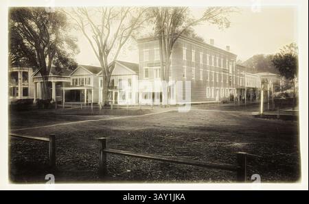 Un campus storico caratterizzato da un notevole edificio circondato da alberi e giardini aperti, che evoca un senso di nostalgia e senza tempo. La struttura presenta elementi architettonici classici, mentre la tranquillità del paesaggio circostante aggiunge al suo fascino., Unknown (americano), Town Square, Berkshire, Massachusetts, tra il 1890 e il 1900, stampa platino, Foglio: 9 7/8 x 16 1/2 pollici (25,1 x 41,9 cm), arte classica con un tocco moderno reinventata da Artotop Foto Stock