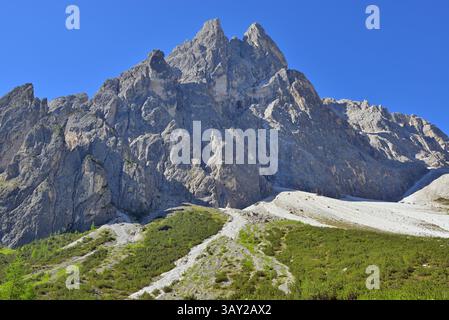 Imponente massiccio montano contro un cielo blu vibrante. Cima una fa parte di una popolare località alpina estiva per escursioni e alpinismo. Dolomiti, Italia. Foto Stock