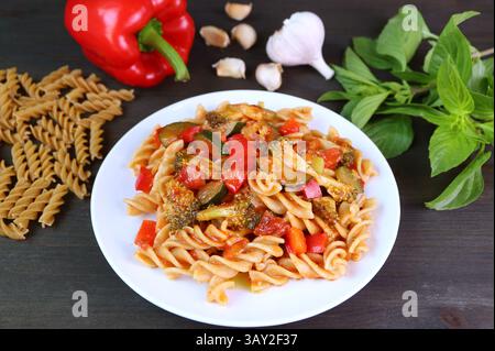 Piatto di Fusilli appena cucinato in salsa di pomodoro e condito con ingredienti Foto Stock
