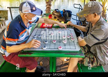 Vecchi uomini thailandesi che giocano a giochi da tavolo sul lago nel Lumphini Park, Bangkok, Thailandia Foto Stock