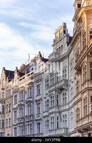 Una fila di edifici storici ornati con facciate intricate e sfumature pastello sotto un cielo sereno. La luce soffusa migliora i dettagli architettonici Foto Stock