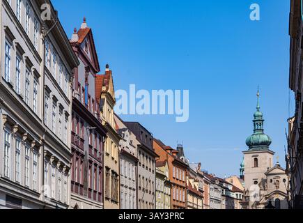 Una vista pittoresca degli storici edifici europei con facciate ornate accanto a un'affascinante torre, adagiata su un cielo azzurro e cristallino, che cattura il vecchio mondo el Foto Stock