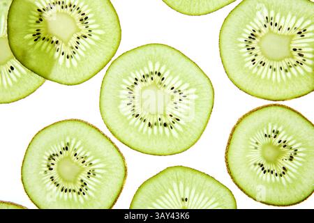 Primo piano di vivaci fette di kiwi disposte su uno sfondo chiaro. L'immagine mostra la polpa verde brillante e i piccoli semi neri, evidenziando la freschezza Foto Stock