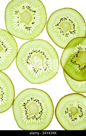 Primo piano di fette di kiwi fresche disposte su uno sfondo chiaro. Il vivace frutto verde mostra una texture dettagliata e semi, mettendo in risalto il suo nat Foto Stock