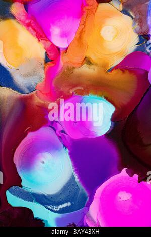 Un'impressionante composizione astratta con vivaci spruzzi d'inchiostro in tonalità rosa, blu, giallo e arancione su uno sfondo testurizzato, creando una dinamica Foto Stock