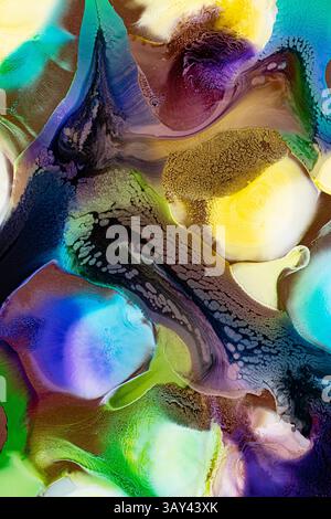 Questa immagine astratta presenta un inchiostro vibrante che si fonde con texture ricche che scorrono su più sfondi colorati, tra cui blu, verde, giallo e viola Foto Stock