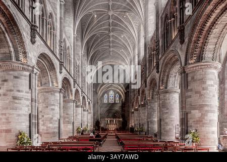 L'interno della cattedrale di Hereford, Herefordshire, Inghilterra Regno Unito. I raggi del sole sono visibili nel fumo di incenso del servizio mattutino della domenica di Pasqua. Foto Stock