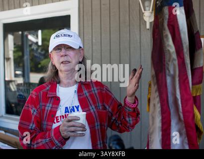 17 ottobre 2016 - Hillsborough, Carolina del Nord, Stati Uniti - EVELYN POOLE-KOBER, vice presidente del governo della contea di Orange, si erge con una bandiera statunitense danneggiata da un incendio presso il quartier generale repubblicano della contea di Orange lunedì, dopo un bombardamento a fuoco nell'ufficio avvenuto sabato. Una bottiglia fiammeggiante è stata gettata attraverso la finestra dell'ufficio, e una svastica e le parole "i repubblicani nazisti lasciano la città o altrimenti" sono state dipinte di nero sul lato di un edificio adiacente durante la notte di sabato. (Immagine di credito: © Jill Knight/TNS via ZUMA Wire) Foto Stock