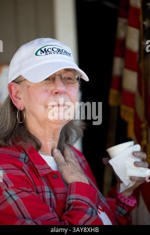 17 ottobre 2016 - Hillsborough, Carolina del Nord, Stati Uniti - EVELYN POOLE-KOBER, vice presidente del governo della contea di Orange, si erge con una bandiera statunitense danneggiata da un incendio presso il quartier generale repubblicano della contea di Orange lunedì, dopo un bombardamento a fuoco nell'ufficio avvenuto sabato. Una bottiglia fiammeggiante è stata gettata attraverso la finestra dell'ufficio, e una svastica e le parole "i repubblicani nazisti lasciano la città o altrimenti" sono state dipinte di nero sul lato di un edificio adiacente durante la notte di sabato. (Immagine di credito: © Jill Knight/TNS via ZUMA Wire) Foto Stock