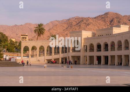 Un edificio dall'architettura tradizionale in Arab Revolt Plaza, città di Aqaba, Giordania, con montagne sullo sfondo. Foto Stock