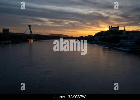 Bratislava, Slovacchia. 20 aprile 2025. Panoramica generale del fiume Danubio a Bratislava durante il tramonto. Sullo sfondo si può ammirare la torre UFO, il ponte SNP, il castello di Bratislava e la cattedrale di San Martino. (Immagine di credito: © Tomas Tkacik/SOPA Images via ZUMA Press Wire) SOLO PER USO EDITORIALE! Non per USO commerciale! Foto Stock