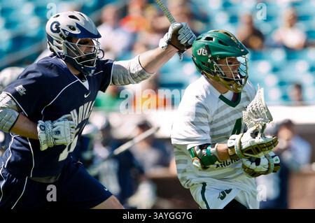 20 febbraio 2011: Il centrocampista dei Jacksonville Dolphins Cameron Mann (4) sfugge al centrocampista di Georgetown Hoyas Max Seligmann (10) durante l'azione di Lacrosse tra Georgetown Hoyas e Jacksonville Dolphins durante il Moe's Southwest Sunshine Classic giocato all'EverBank Field di Jacksonville, Florida. Georgetown ha battuto in finale Jacksonville 14-11.(Credit Image: © Gray Quetti/Cal Sport Media/ZUMAPRESS.com) Foto Stock