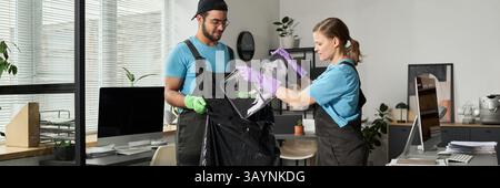 Lavoratori che gettano rifiuti in Bag in Office Foto Stock