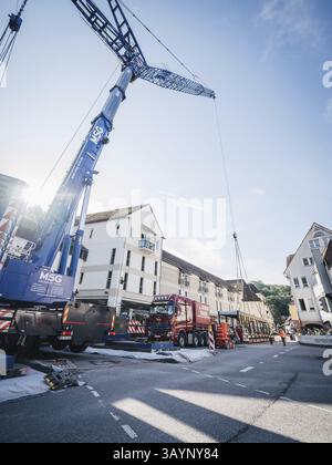 Calw, Baden-Wuerttemberg, Germania, Una grande gru solleva un oggetto pesante in un ambiente urbano in una giornata di sole, in Europa Foto Stock