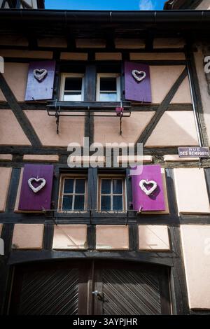 Edificio romantico con persiane a cuore a Riquewihr, Alsazia, Francia edificio romantico con persiane a cuore a Riquewihr, Alsazia, Francia Foto Stock