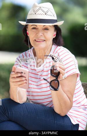 donna matura, attraente e di stile, pensata per usare il cellulare all'aperto Foto Stock
