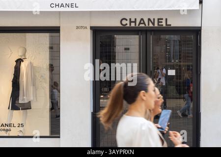 Venezia, Italia - 20 aprile 2025: Logo boutique Chanel e vetrina con gli acquirenti di passaggio a Venezia Foto Stock