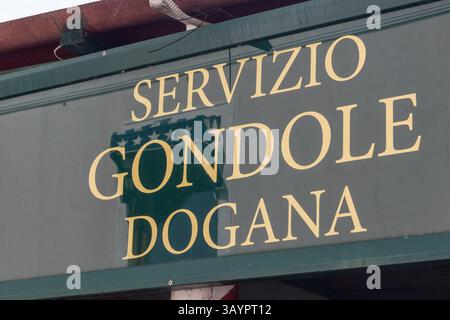 Venezia, Italia - 20 aprile 2025: Servizio di gondola cartello Dogana presso l'area d'imbarco sul lato del canale a Venezia Foto Stock