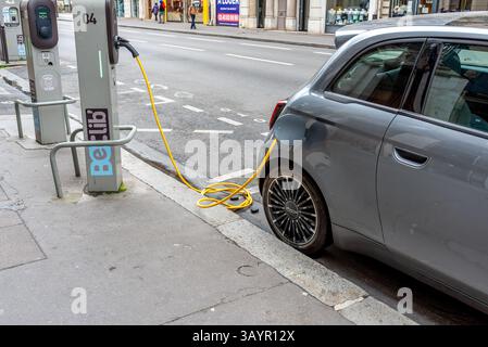 Un'auto elettrica in una stazione di ricarica a Parigi. Ricarica di un veicolo elettrico Foto Stock