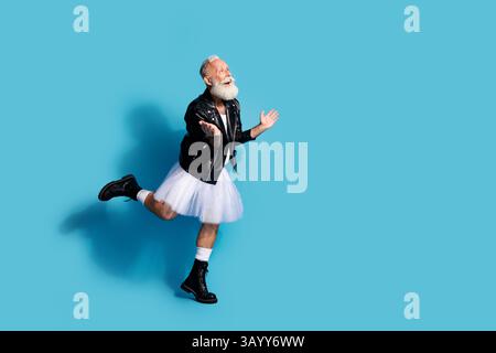 Foto di un uomo anziano non binario che danza sembrano spazi vuoti lasciati stupire dai vestiti femminili sfondo blu isolato Foto Stock