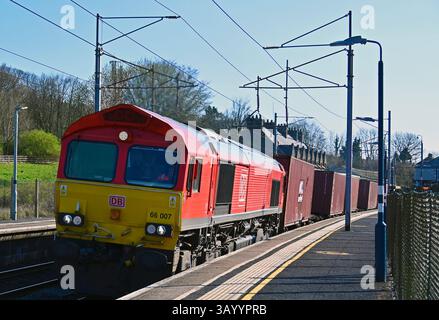 DB Cargo UK Goods locomotiva No.66 007 Passing Oxenholme Rail Station, West Coast Main Line, Cumbria, Inghilterra, Regno Unito, Europa. Foto Stock