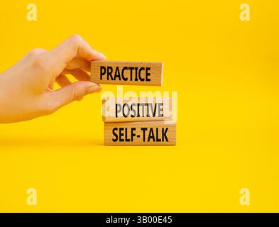 Esercitarsi con il simbolo di autoapprendimento positivo. Le parole concettuali esercitano un'autocomunicazione positiva su blocchi di legno. Mano d'affari. Bellissimo sfondo giallo. Affari Foto Stock