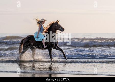 St. Augustine Beach, Florida, Stati Uniti. 23 aprile 2025. Una donna cavalca un cavallo lungo la costa durante una sessione fotografica al Florida Photo Fest a St. Augustine Beach, Florida, il 23 aprile 2025. Il festival fotografico annuale attrae fotografi da tutto il paese. (Immagine di credito: © Ronen Tivony/ZUMA Press Wire) SOLO PER USO EDITORIALE! Non per USO commerciale! Foto Stock