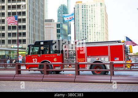 Chicago, Illinois, Stati Uniti d'America - 22 agosto 2024: Camion dei vigili del fuoco Chicago Fire Department Engine 13 sul ponte DuSable, bandiere americane che sventolano Foto Stock