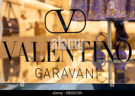 Venezia, Italia - 20 aprile 2025: Vetrina boutique Valentino Garavani con accessori e sfilata di moda viola Foto Stock