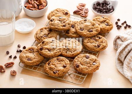 Biscotti con scaglie di cioccolato e noci pecan, biscotti appena sfornati su una griglia di raffreddamento Foto Stock