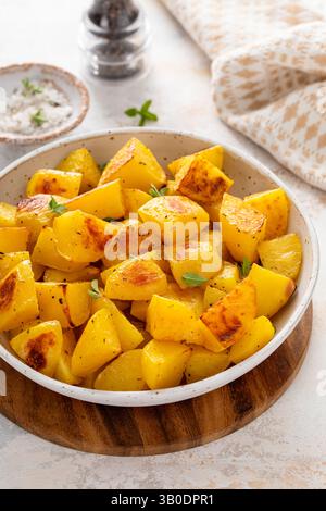 Patate arrosto al forno in un recipiente da portata cotto con aglio, erbe e spezie Foto Stock