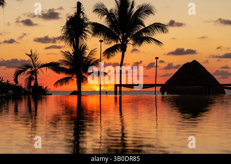 L'alba sul Golfo del Messico si riflette nella piscina a sfioro del resort Foto Stock