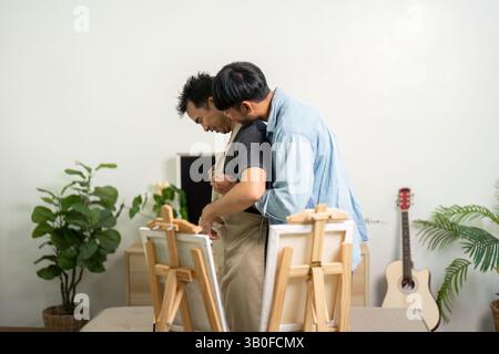 Coppia e Artistic Bond. Una coppia gay condivide un momento tenero mentre si prepara per una sessione di pittura. Foto Stock